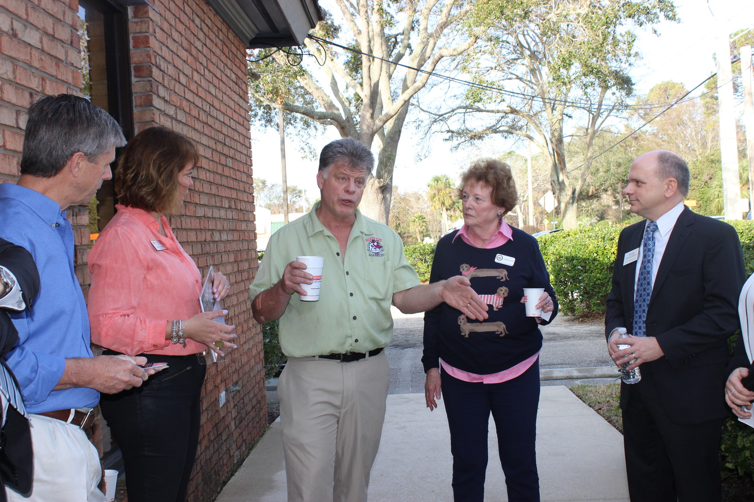 Fluffy Cuts owner Brian Anderson (center) speaks with fellow Chamber members at the “Before Hours” event on Feb. 7.
