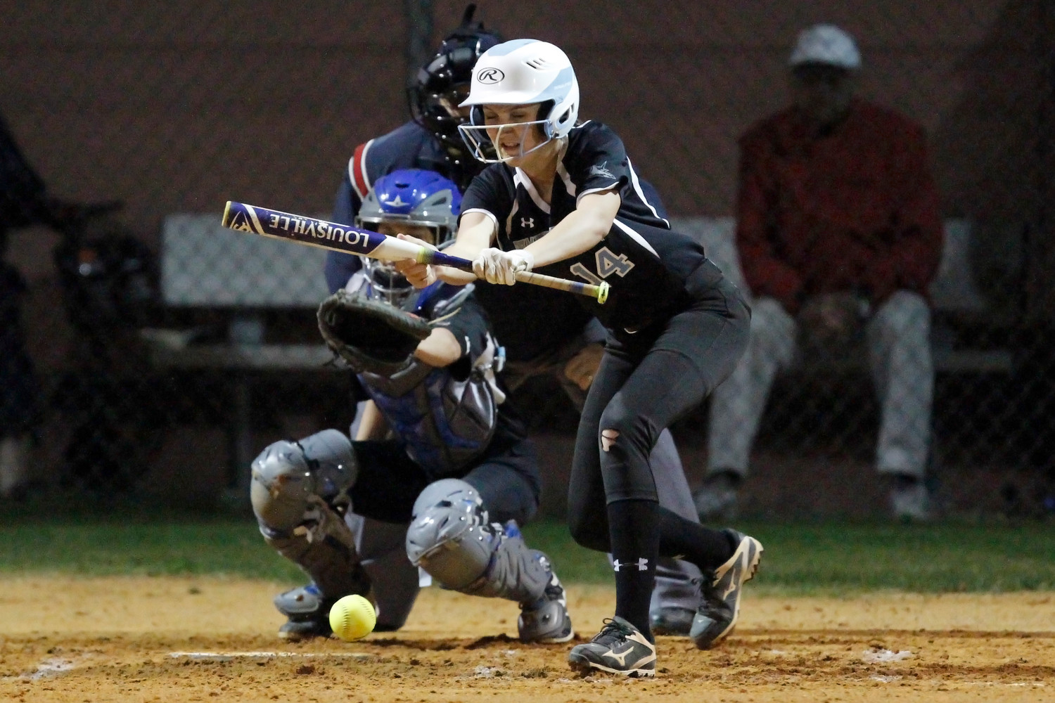 Catherine Beaton (14) of the Sharks drops a bunt in front of home plate.
