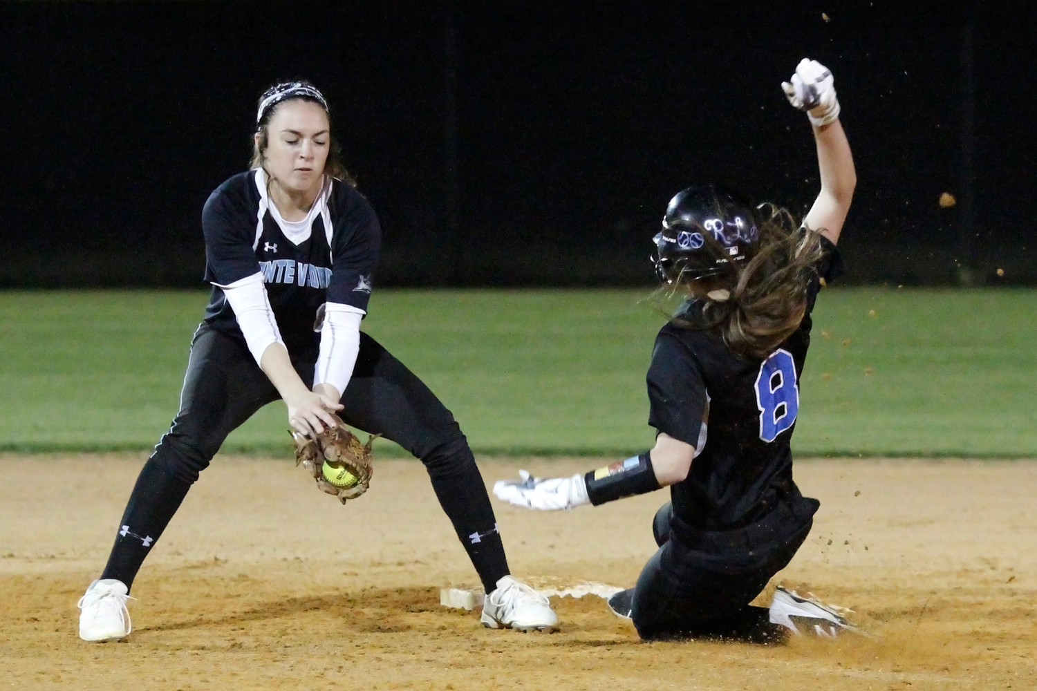 Sharks shortstop Michelle Leone takes the throw from catcher Audrey Matt 
before applying the tag to catch the runner stealing.