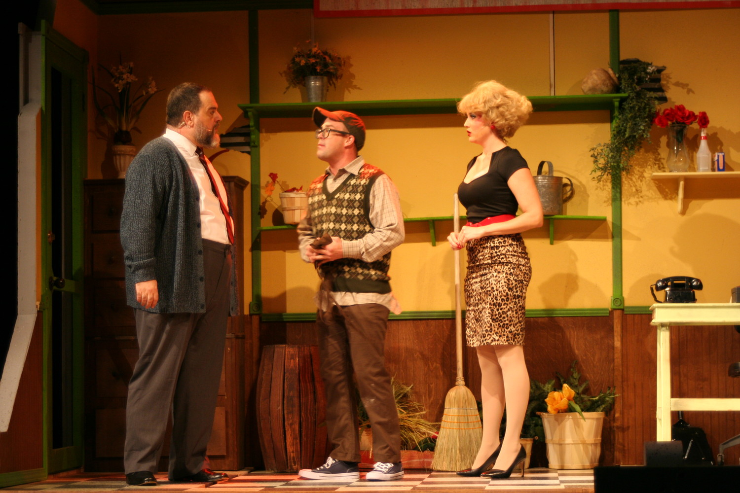 Seymour (center) and Audrey converse with their boss, Mr. Mushnik, at the flower shop