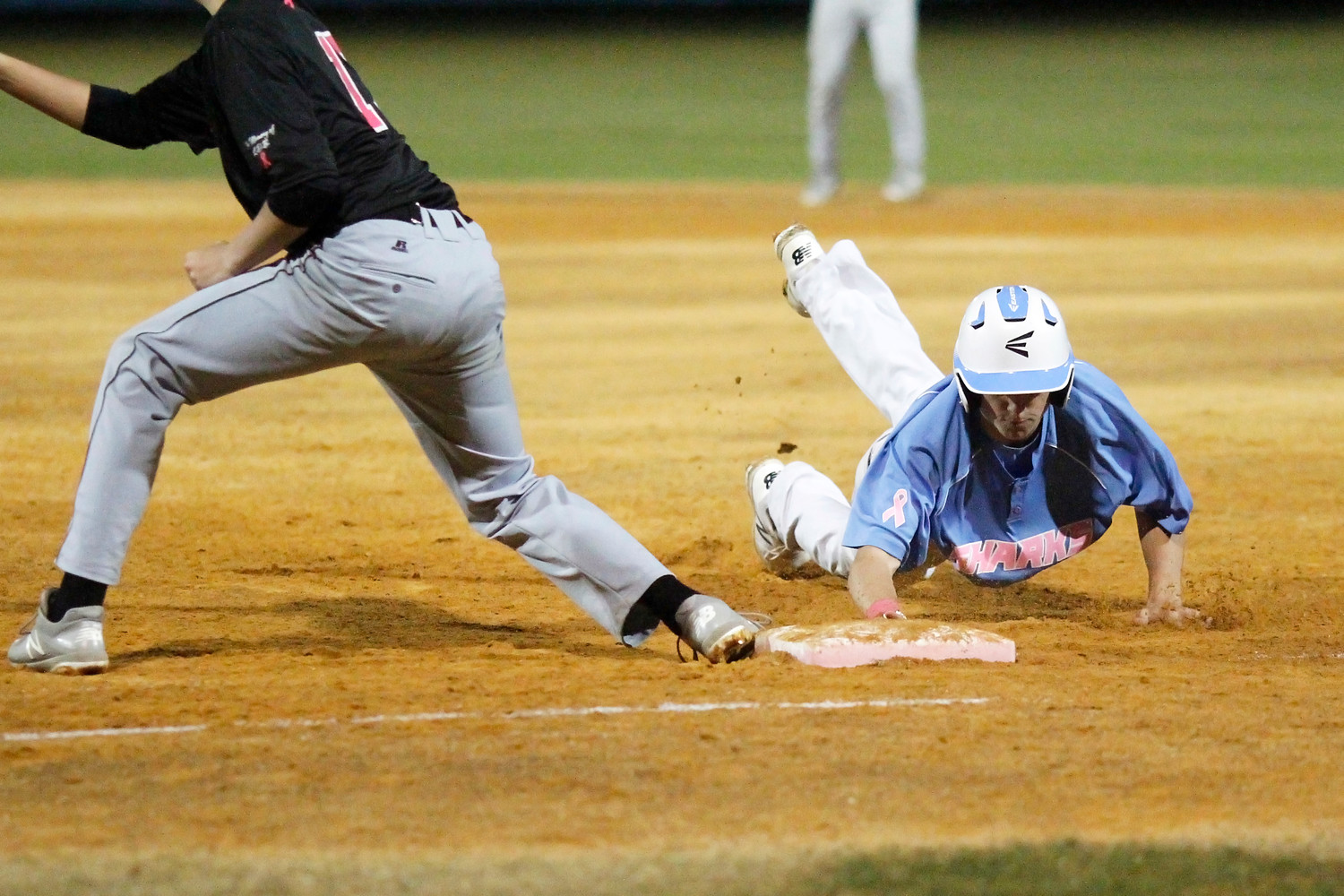 The Sharks’ Cody Nelson (4) slides back safely to first against Episcopal.