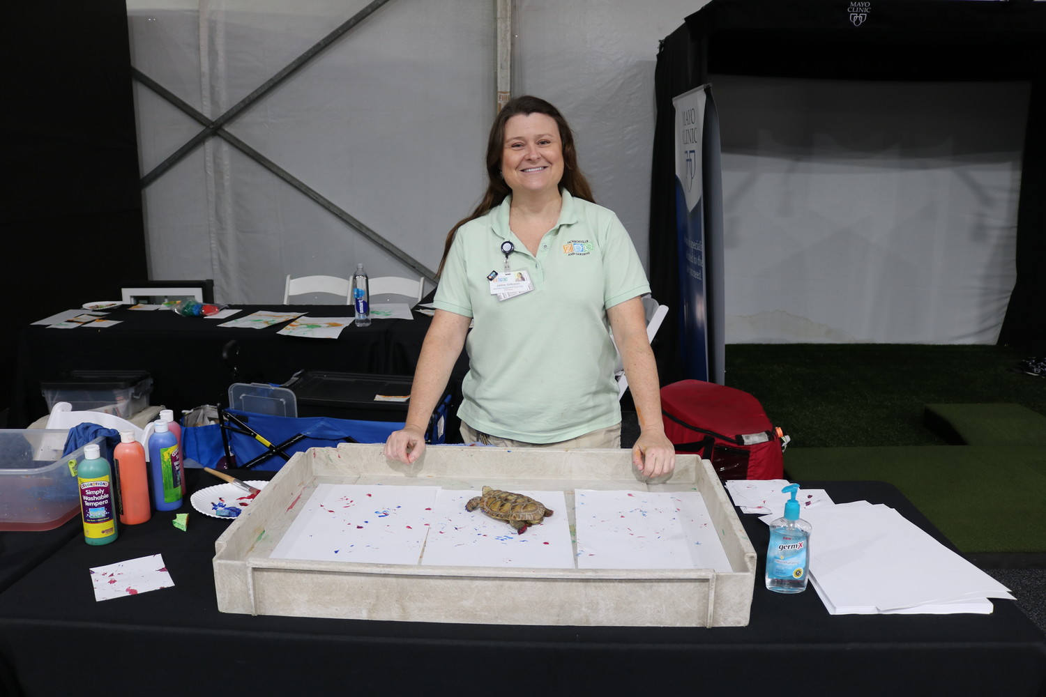 Jamie Gilkison, an education engagement supervisor with the Jacksonville Zoo, poses for a photo behind the Jacksonville Zoo's booth.