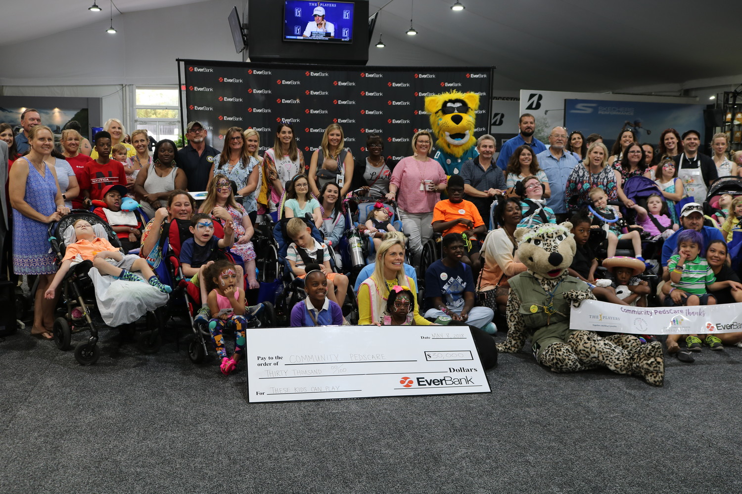 Attendees of the “These Kids Can Paint” event held May 8 at THE PLAYERS Championship pose for a photo with a $30,000 check for Community PedsCare courtesy of EverBank.