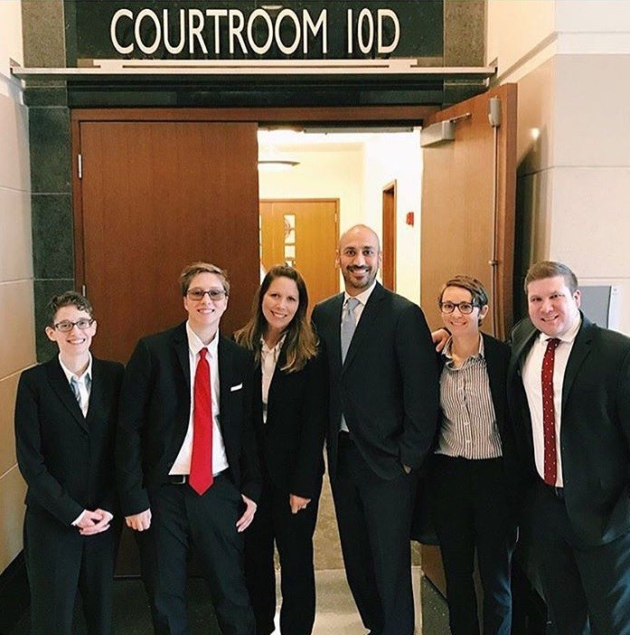 Drew Adams (second from left) and his mother Erica Kasper (third from left) gather with the Lambda Legal attorneys following a federal trial in Jacksonville.