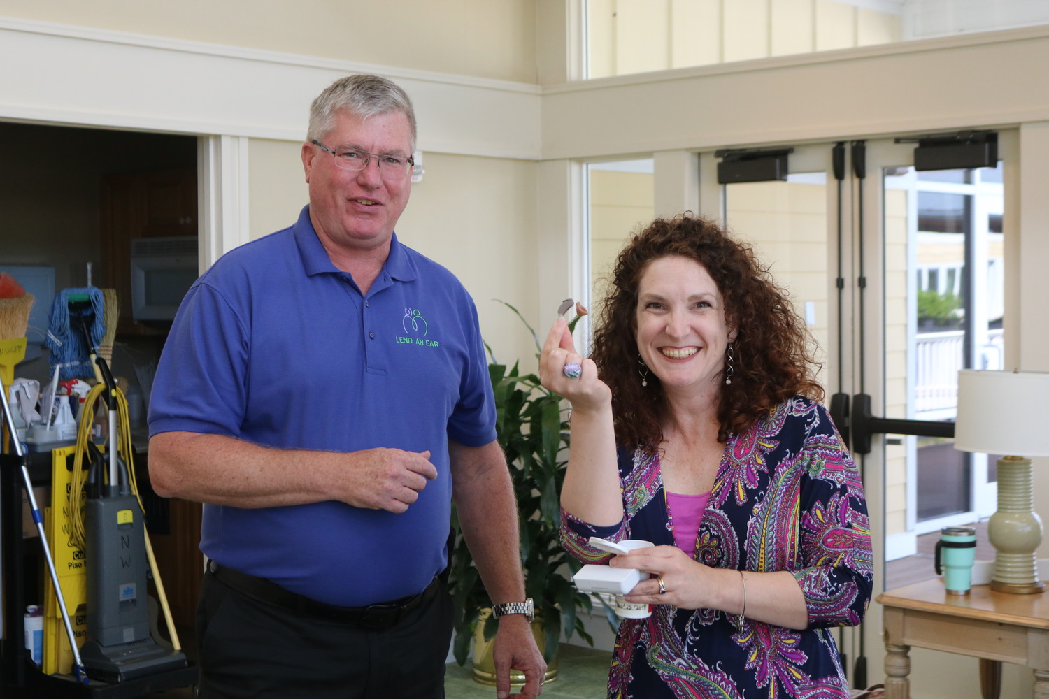 Sonia Howley of the St. Johns County School District celebrates as she receives the donated hearing aids from Lend an Ear Outreach Executive Director Scott Hetzinger.