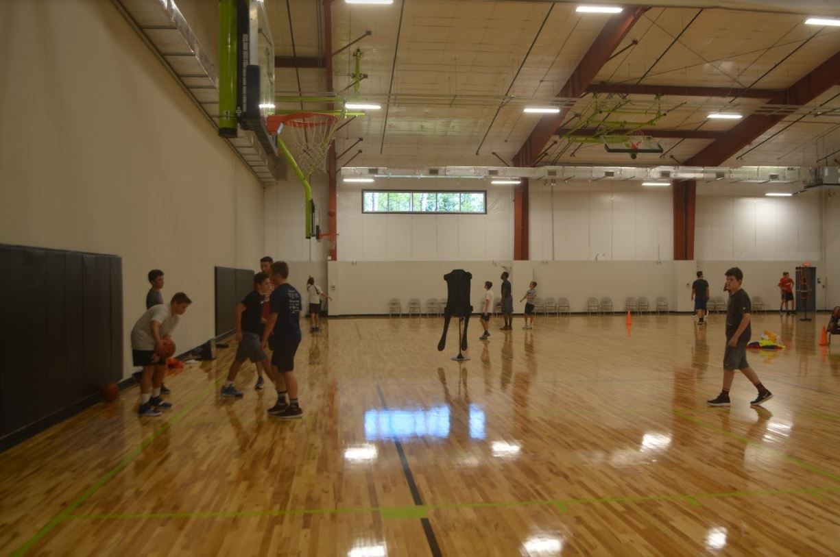 Basketball players shoot some hoops on the court at the ABOVE Athletics facility.