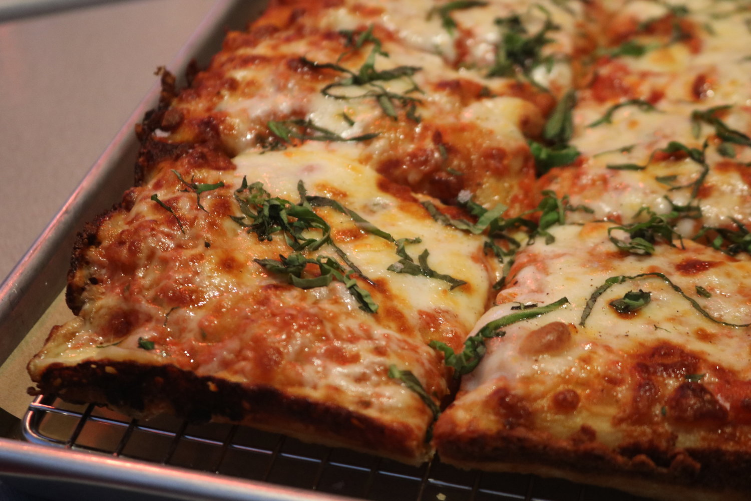 The traditional margherita pizza is topped with tomato sauce, mozzarella and basil.