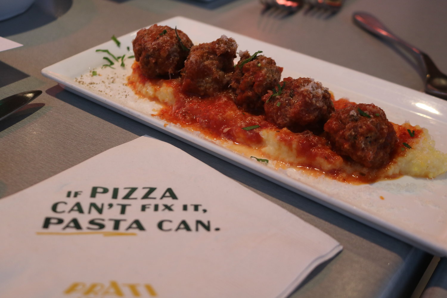 The fontina meatball starter is served with polenta, marinara and basil.