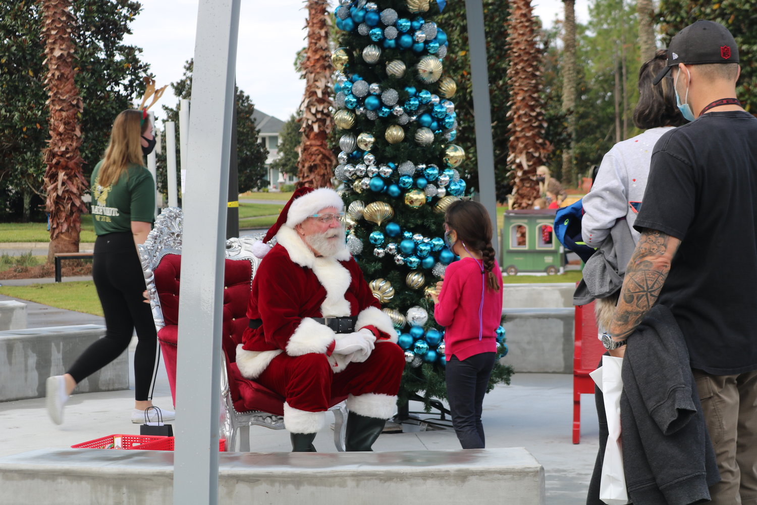 Santa Claus greets children from a safe distance to spread Christmas cheer.