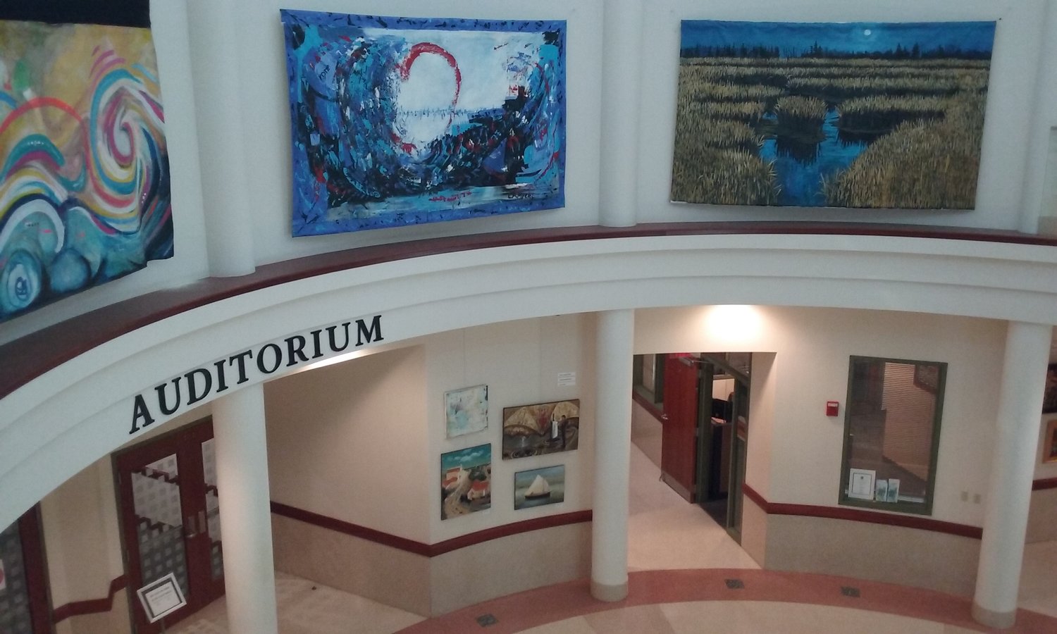 Large paintings hang around the top portion on the rotunda. From left are “Early Marley Morning” by Don Kight, “Emergence” by Lisa Myers and “Full Moon Marsh” by Ken Vallario. Not pictured: “Matanzas” by Patrick Madden.