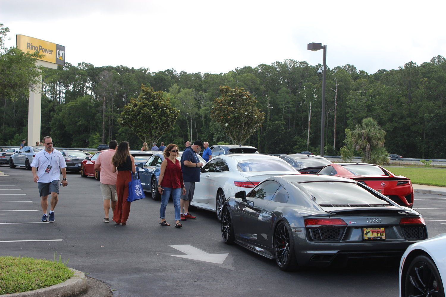 Attendees mingle and admire the luxury vehicles lined up to participate in the 45-mile-long charity drive.