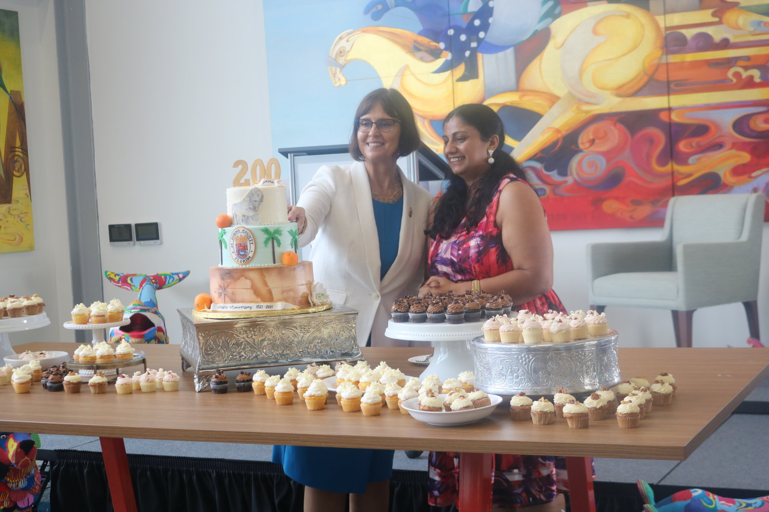 State Rep. Cyndi Stevenson, left, and Gurpreet Misra examine a cake celebrating the county’s bicentennial during grand opening festivities for the link on Wednesday, July 14.