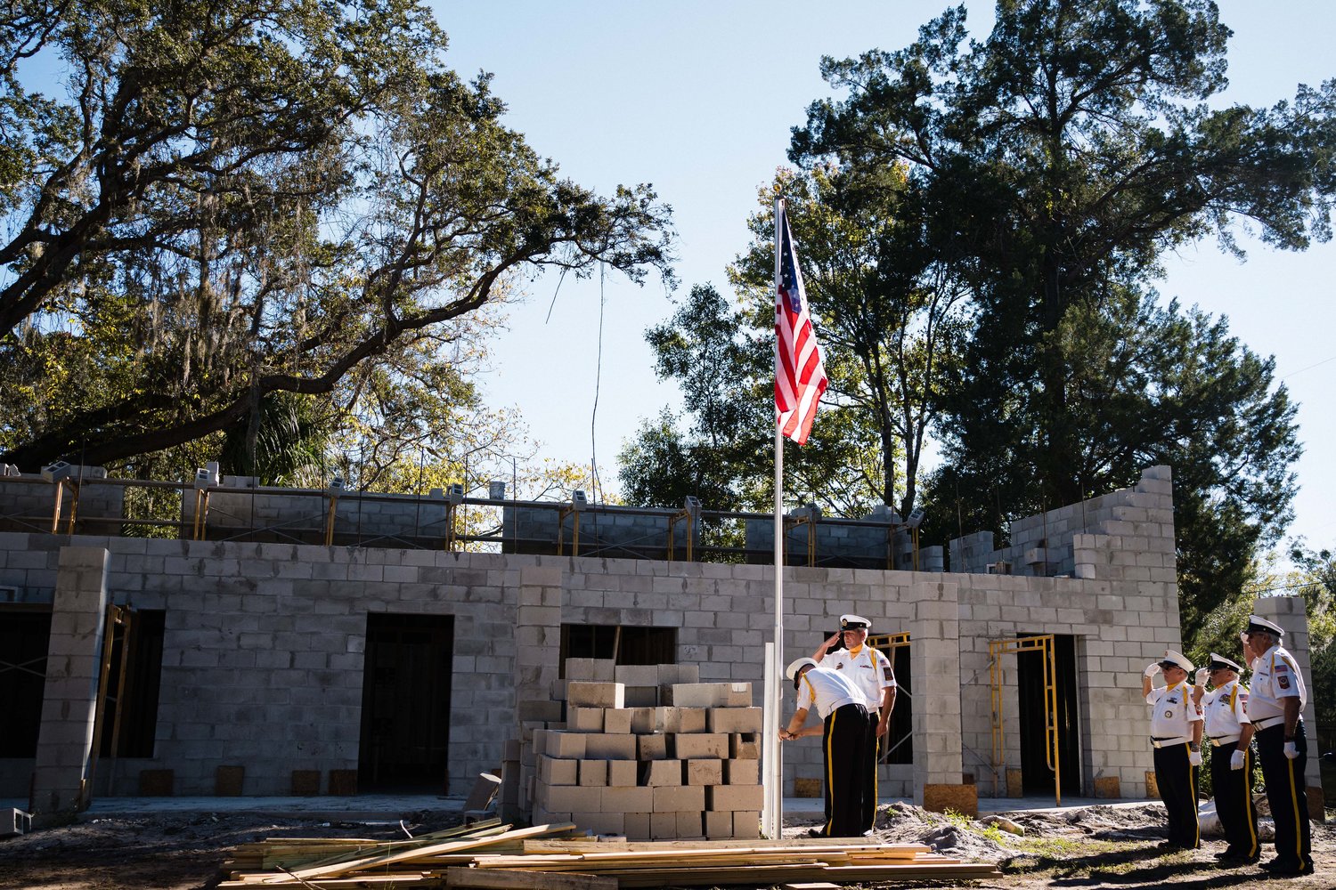 The St. Augustine Honor Guard raises the flag on the site where Patriot Place is being constructed.