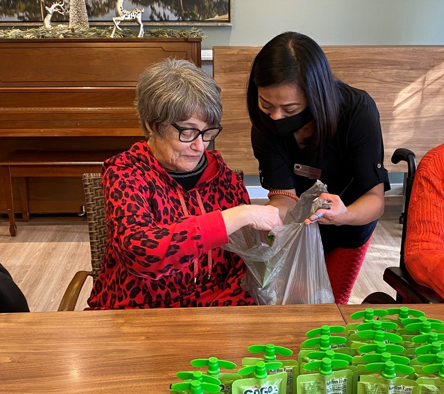 A resident of Ponte Vedra Gardens and a program assistant fill bags with food to be given to children who might otherwise go hungry on weekends.