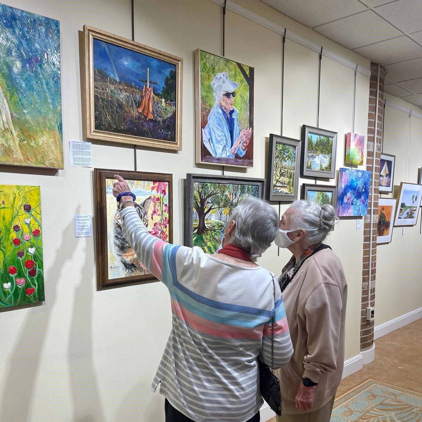 Visitors enjoy the paintings on display at the Cypress Village Visual Arts Show.