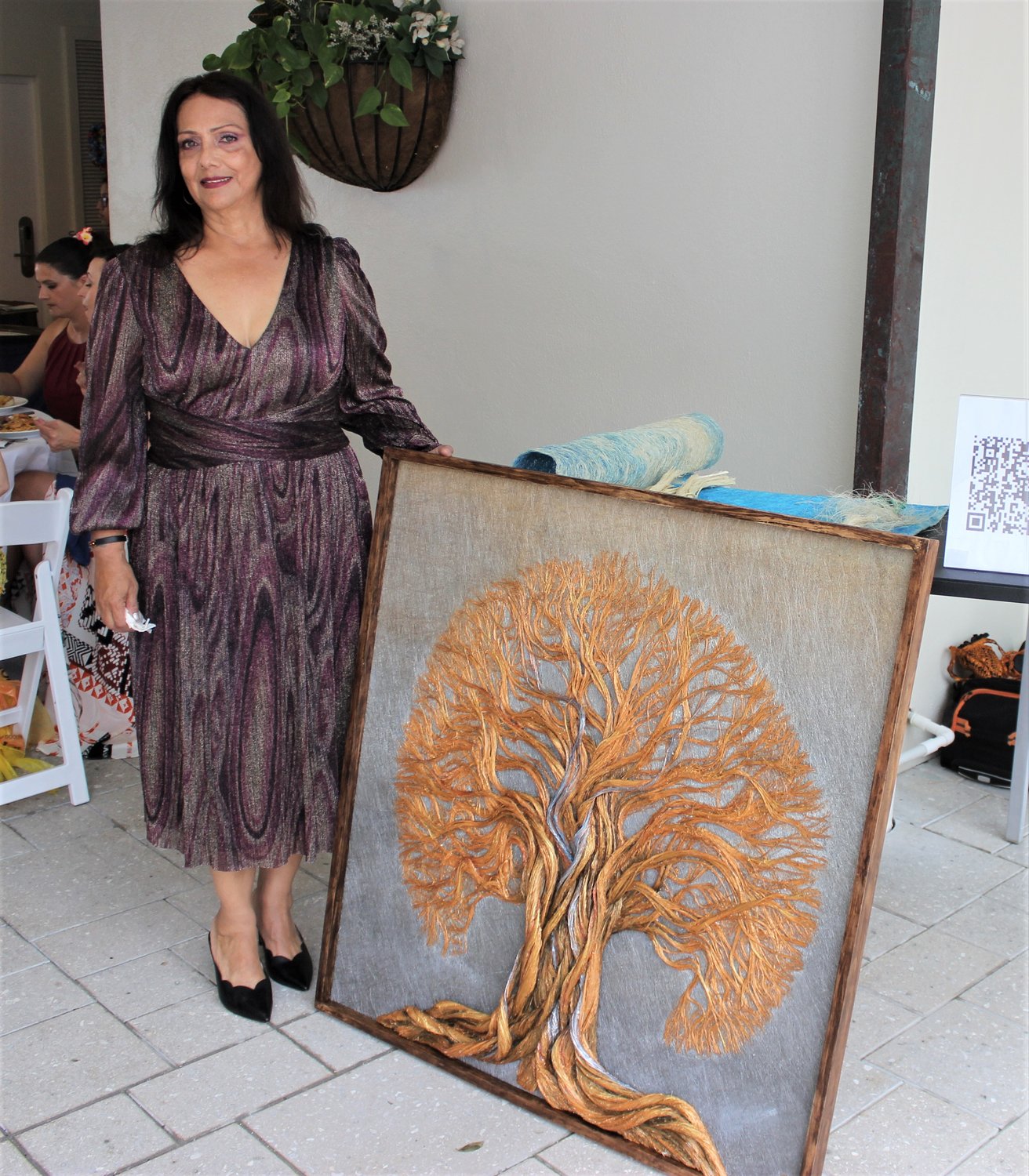 Piedad Camacho shows off one of her fiber works of art at Beaches, A Celebration of the Arts.