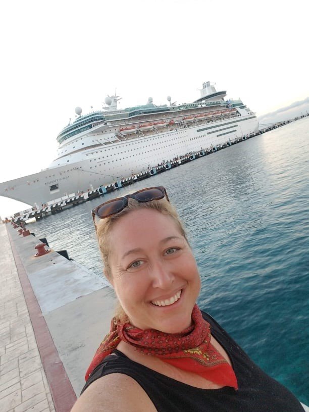 Sarah Stecker, CEO and founder of Travel Advisors Unlimited LLC, takes a selfie with a Royal Caribbean cruise ship in the background. This Tampa-to-Cuba trip was the last just before the pandemic forced a shut-down. Today, cruises are coming back big time.