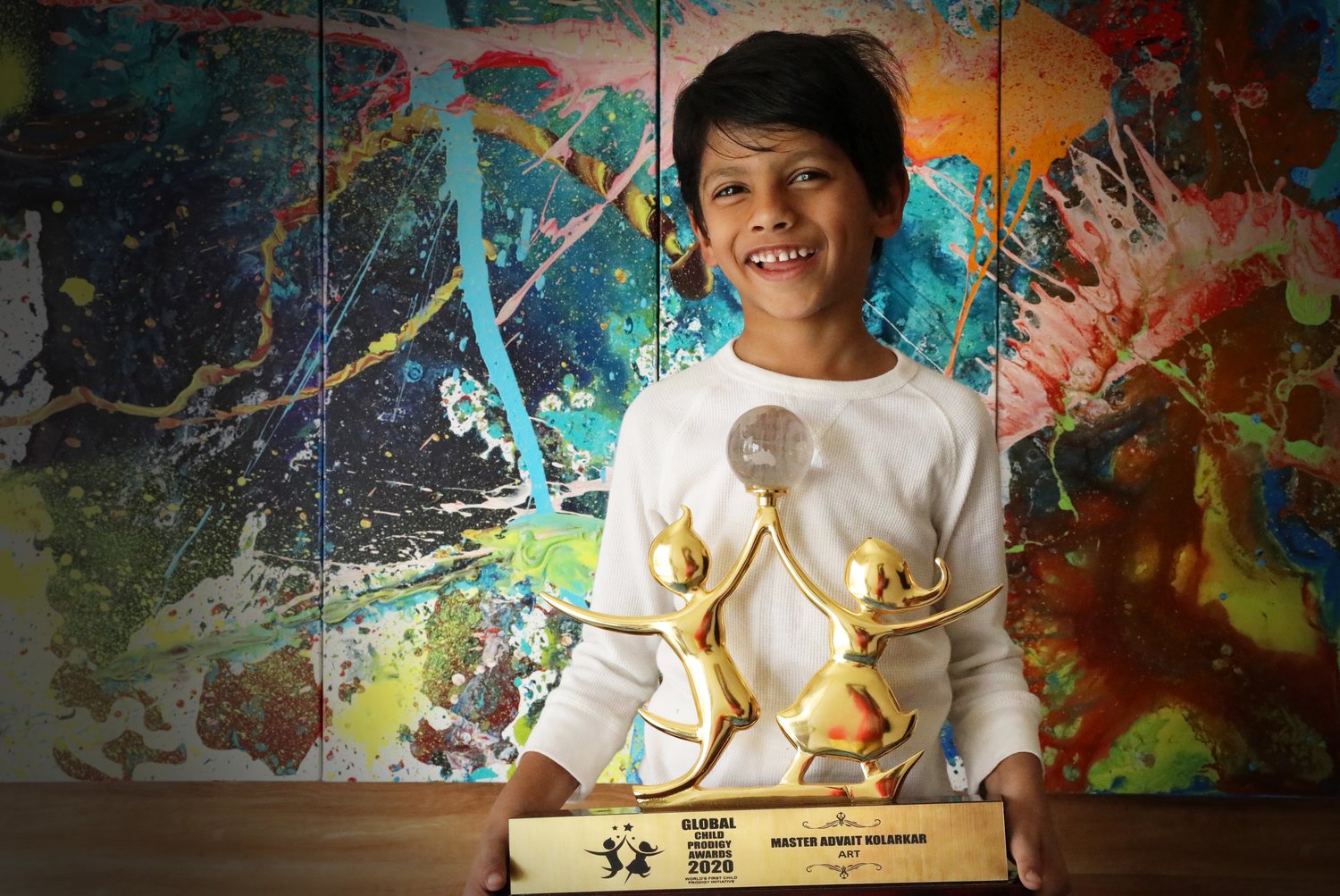 Advait Kolarkar holds up his 2020 Global Child Prodigy Award.