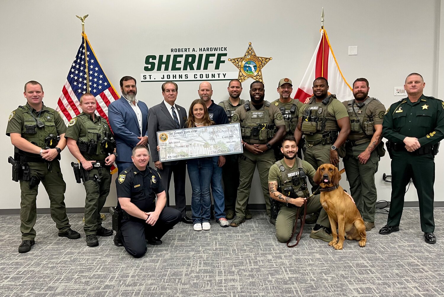 Sen. Tom Wright presents K9s United board members with a $400,000 state grant, along with St. Johns County Sheriff Robert Hardwick and deputies, and representatives of the Nassau County Sheriff's Office.