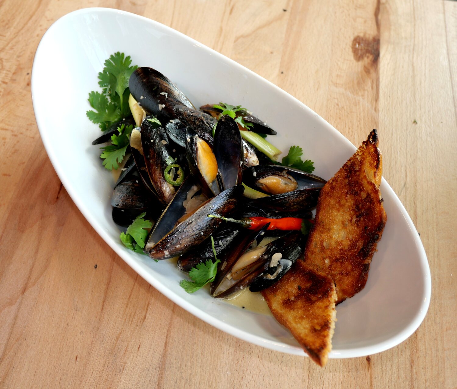 Thai Style Mussels with sweet and spicy lemongrass, lime, coconut, red chili, ginger and garlic